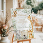 Editable safari baby shower welcome sign Canva template with watercolour monkey, giraffe, elephant, lion cub, and zebra surrounded by eucalyptus and tropical leaves with gold accents on a white background
