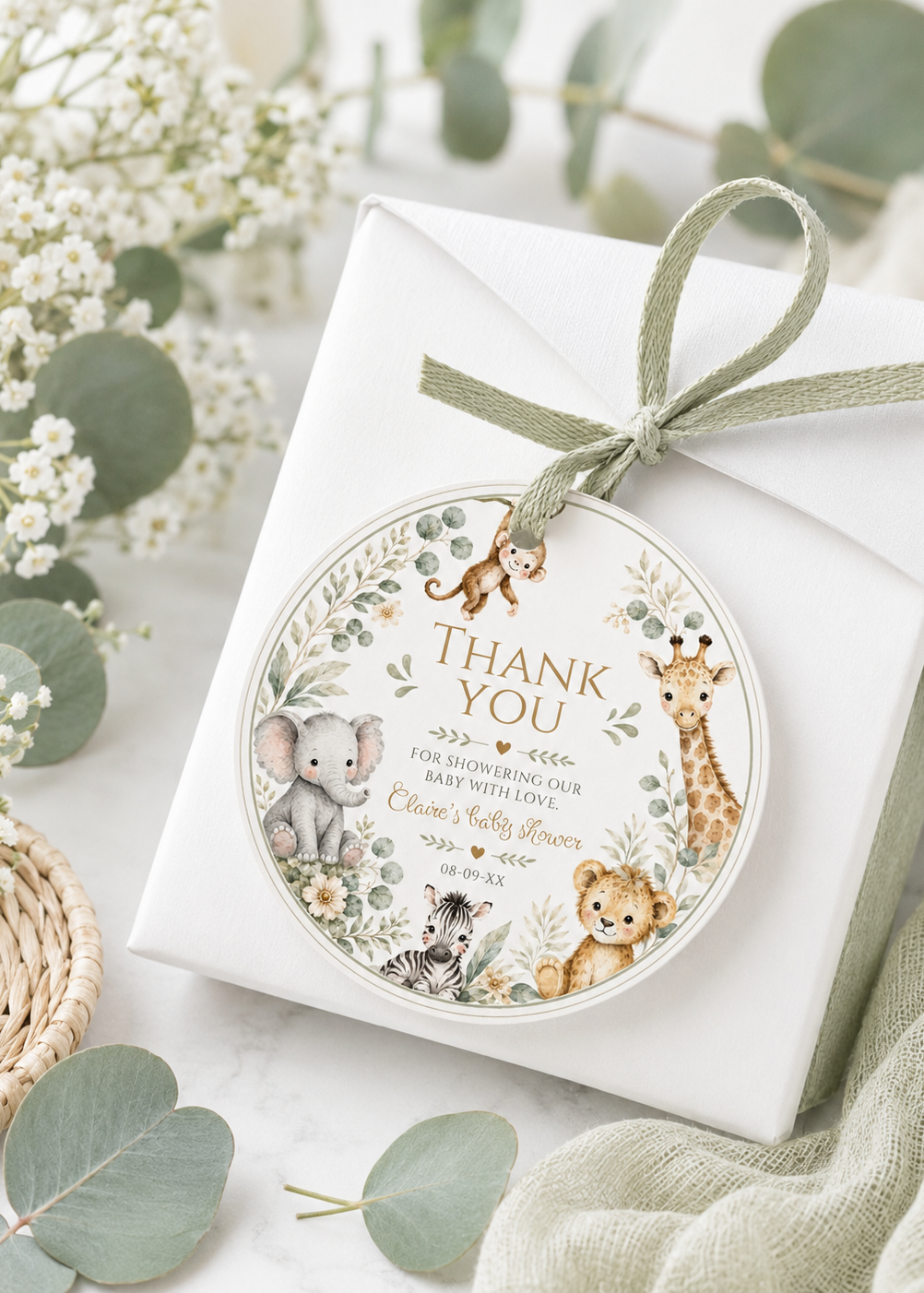 Editable safari baby shower round thank you sticker Canva template with watercolour monkey, giraffe, elephant, lion cub, and zebra in a eucalyptus and tropical leaf wreath on a cream background