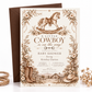 Cowboy baby shower invitation with a brown rocking horse, cowboy boots and hat, rustic barn, and neutral floral border