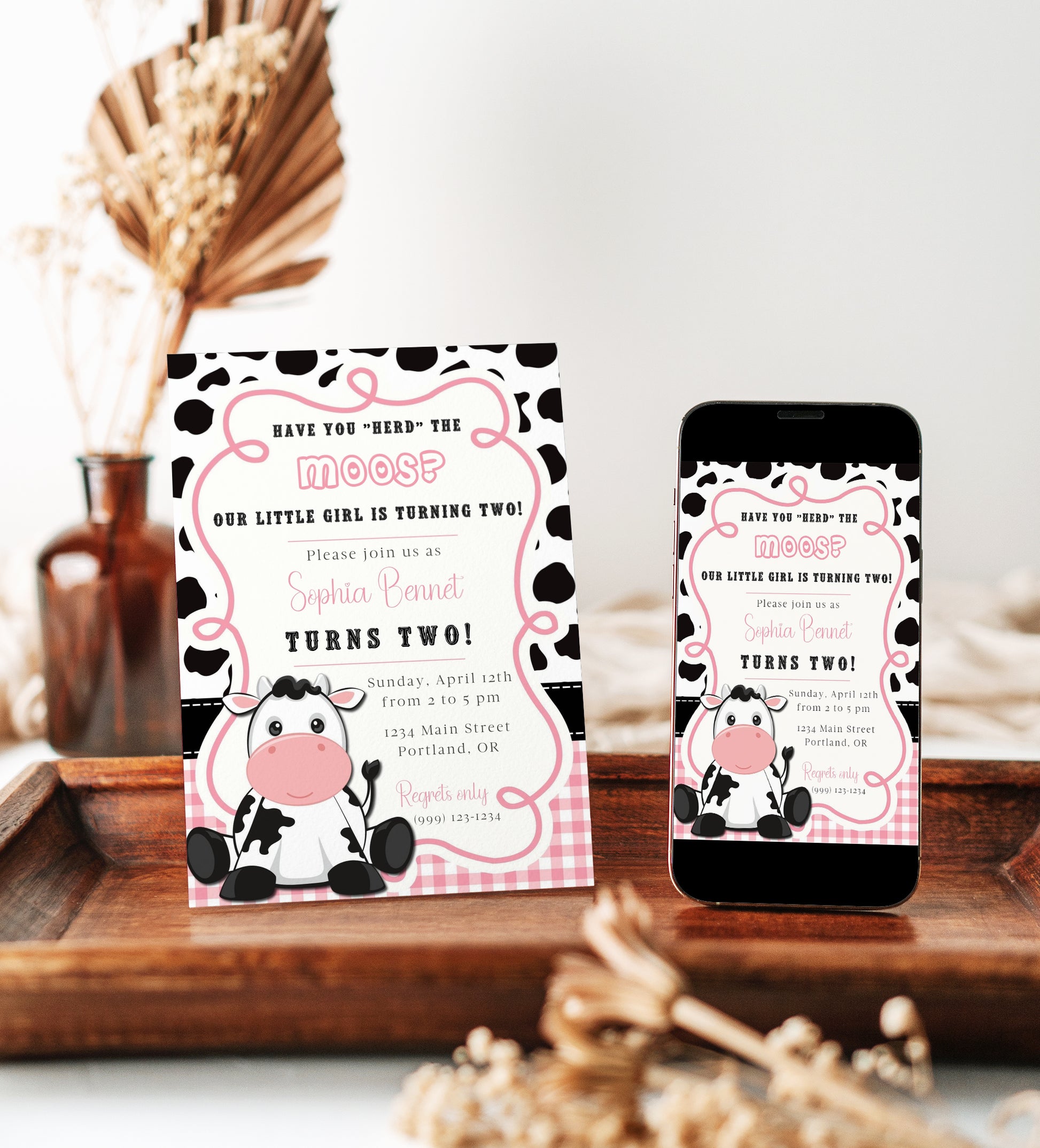 Cow print girl birthday invitation with a cartoon cow, cow spots, and pink gingham in black, white, and pink