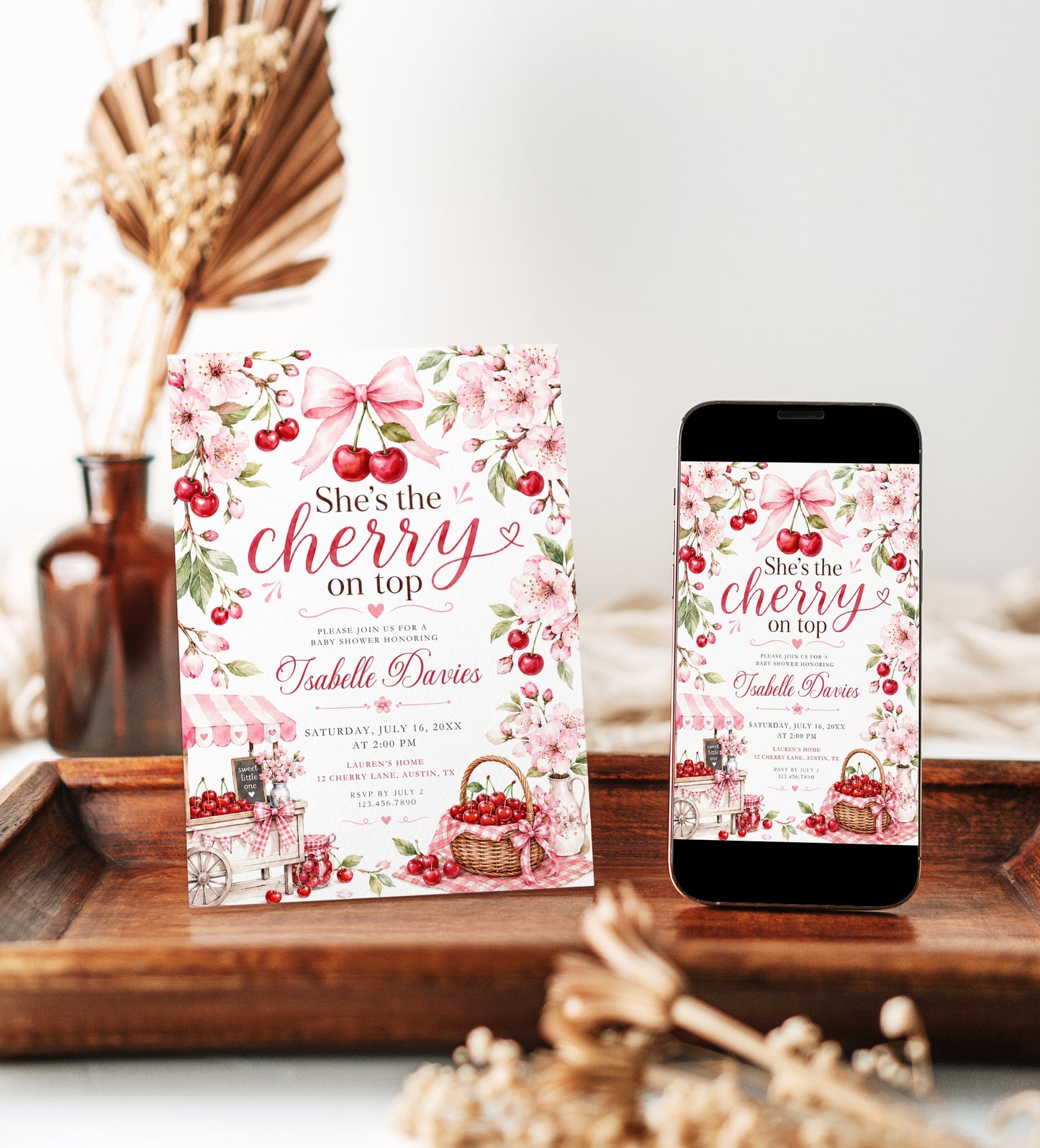 Cherry baby shower invitation featuring red cherries, pink cherry blossoms, blush gingham bows, cherry cart, basket and floral details.
