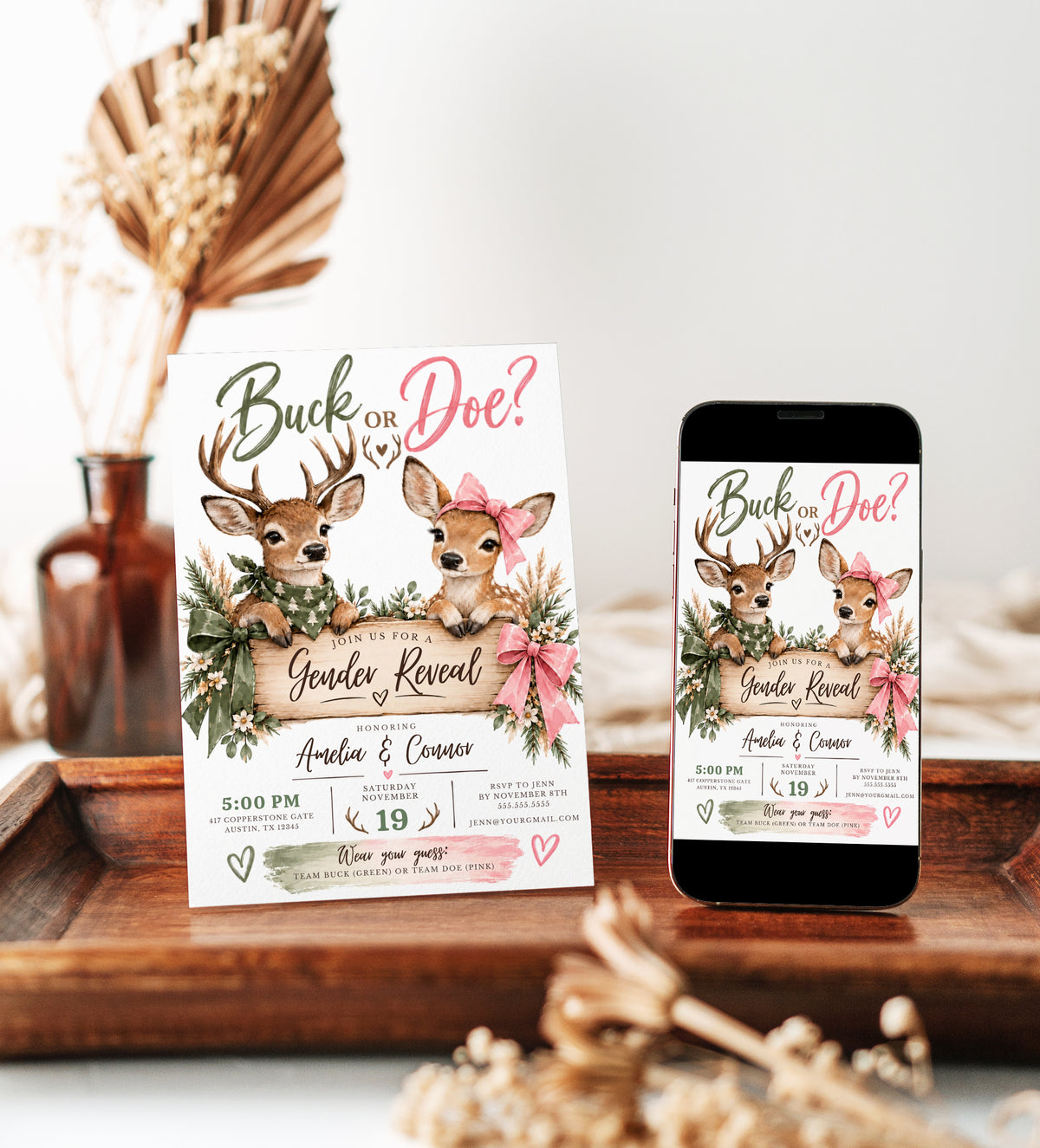 Buck or Doe gender reveal invitation with an antlered deer in a green bandana, a doe wearing a pink bow, rustic wooden sign, greenery, and pink and green ribbons