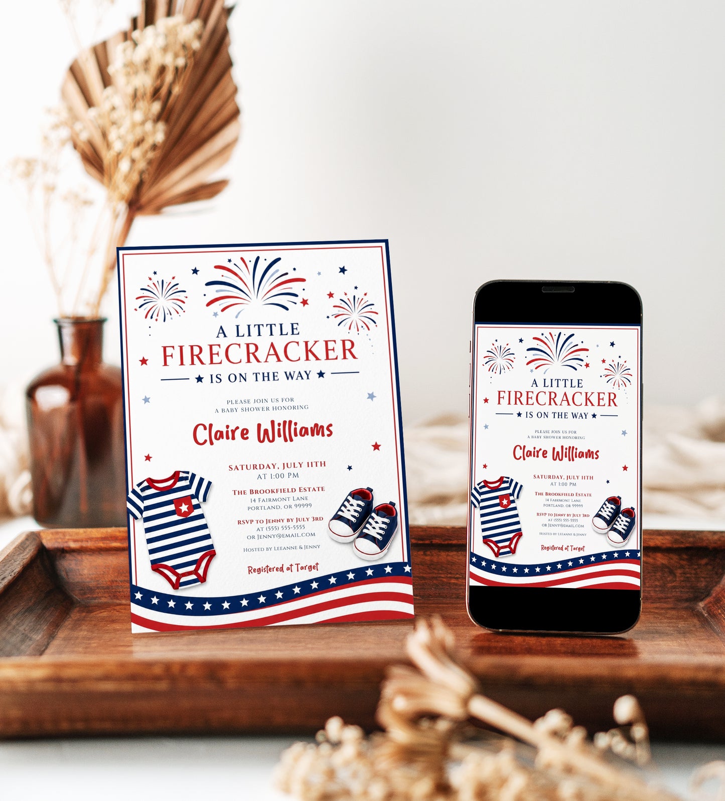 Editable firecracker baby shower invitation Canva template with illustrated fireworks, striped navy onesie, red and navy sneakers, stars and stripes banner, and bold patriotic typography on a white background