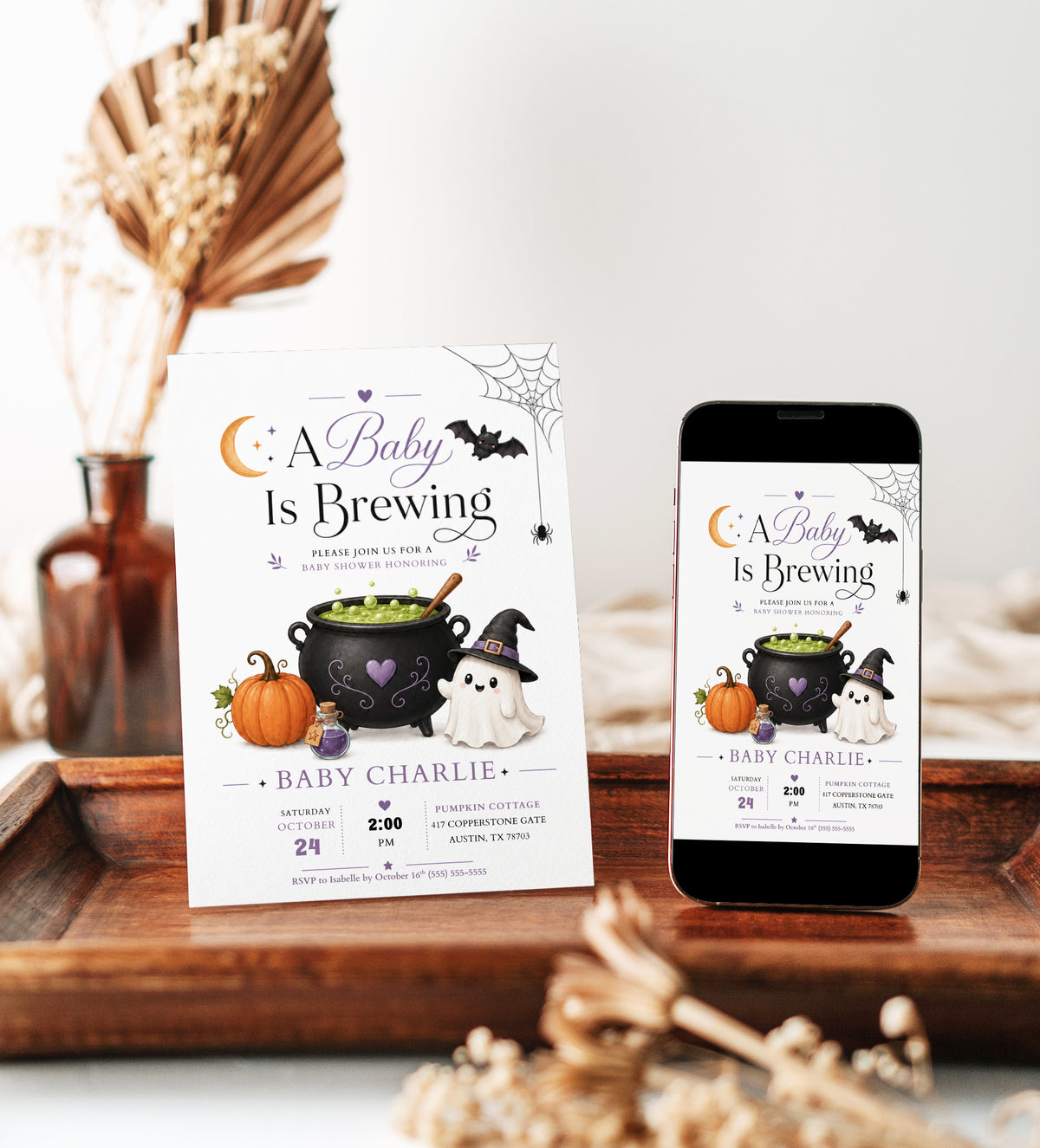 A Baby Is Brewing baby shower invitation with bubbling cauldron, pumpkin, potion bottle, ghost in witch hat, bat, crescent moon, and Halloween baby shower details