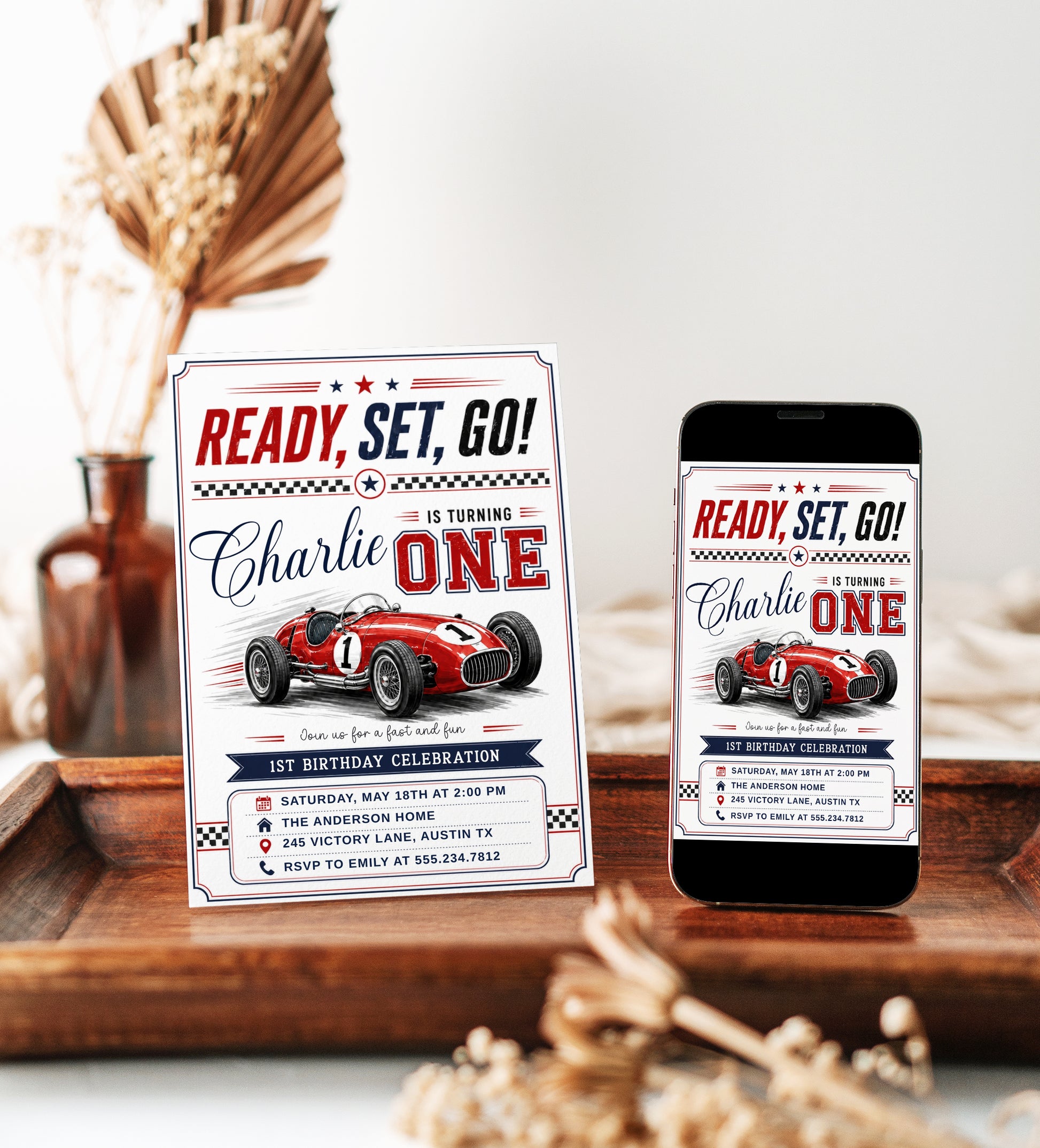 Race car first birthday invitation with red vintage race car, checkered flags, varsity ONE lettering, racing stripes, stars, and bold boys 1st birthday details