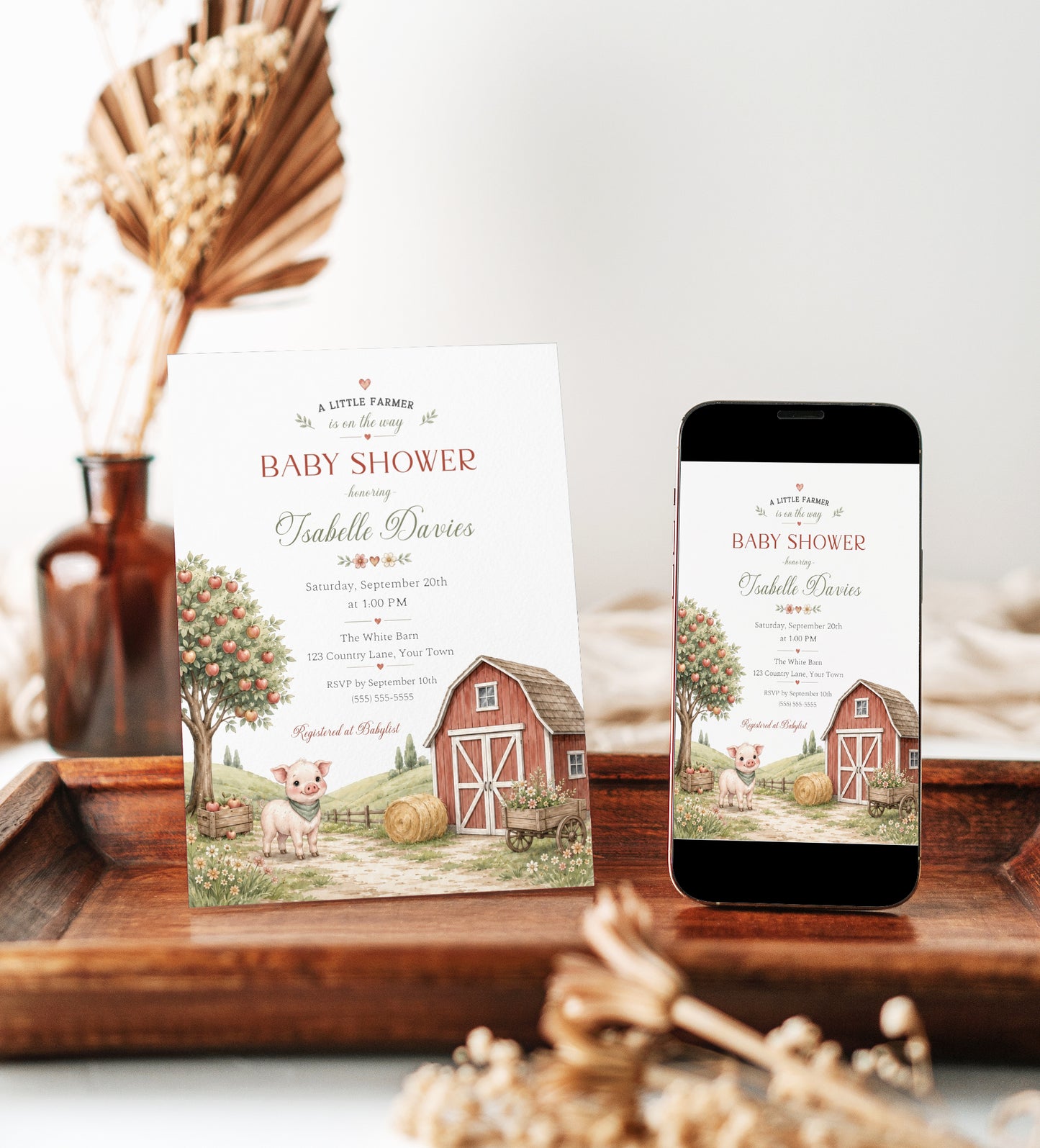 Little farm baby shower invitation with red barn, apple tree, piglet, hay bale, flower cart, rolling hills, fence, wildflowers, and soft farmhouse details