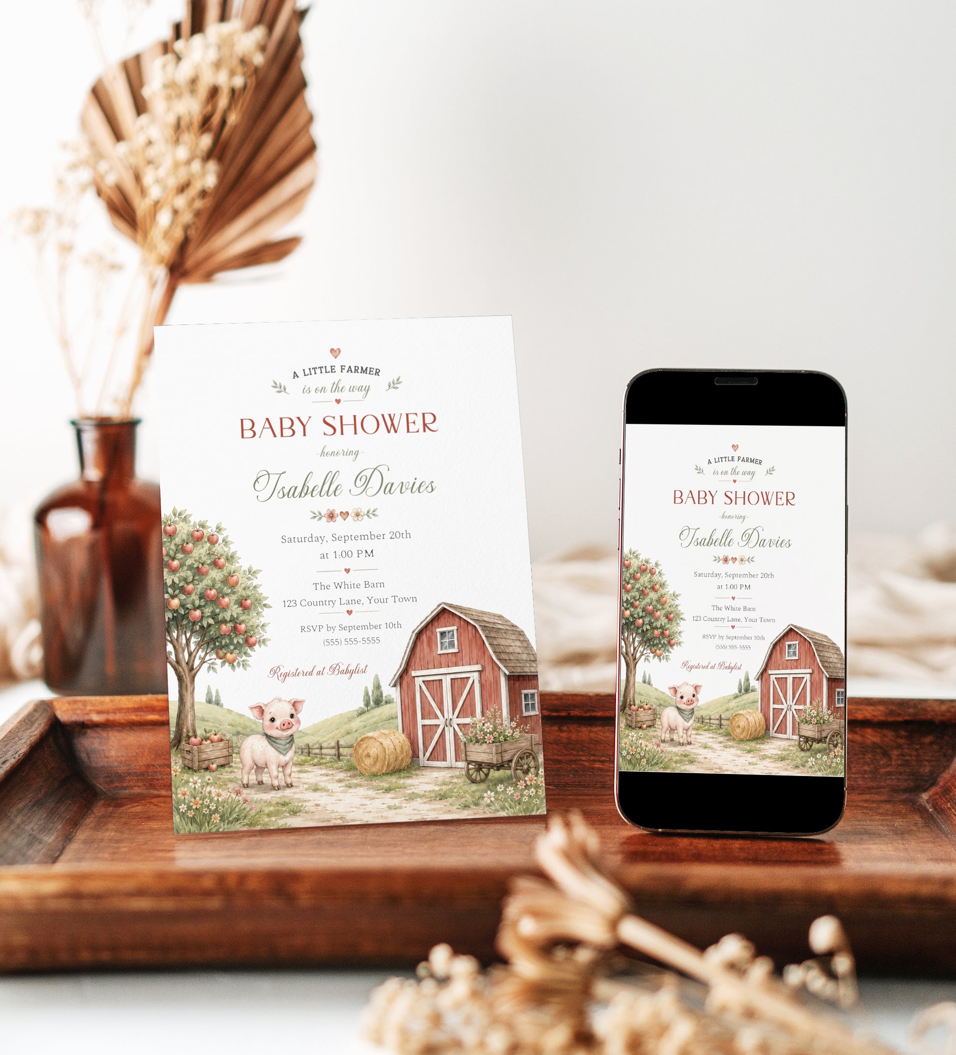 Little farm baby shower invitation with red barn, apple tree, piglet, hay bale, flower cart, rolling hills, fence, wildflowers, and soft farmhouse details