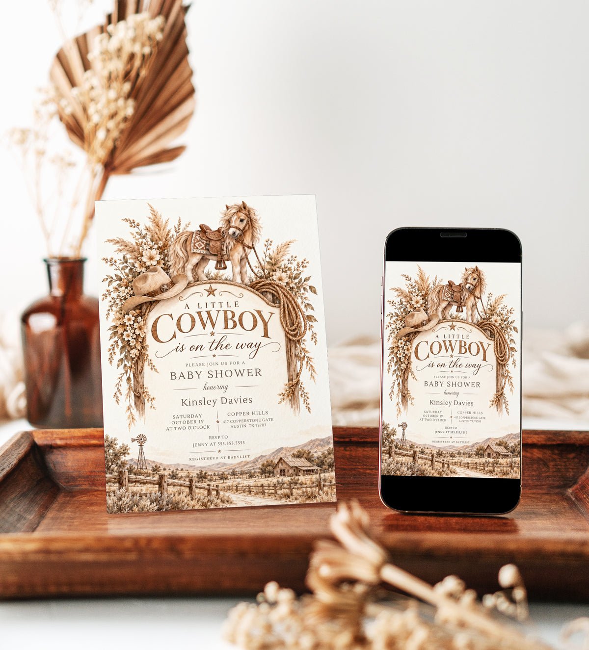Cowboy baby shower invitation with a saddled horse, cowboy hat, lasso, dried florals, and rustic ranch scene in brown and cream for a western baby boy shower