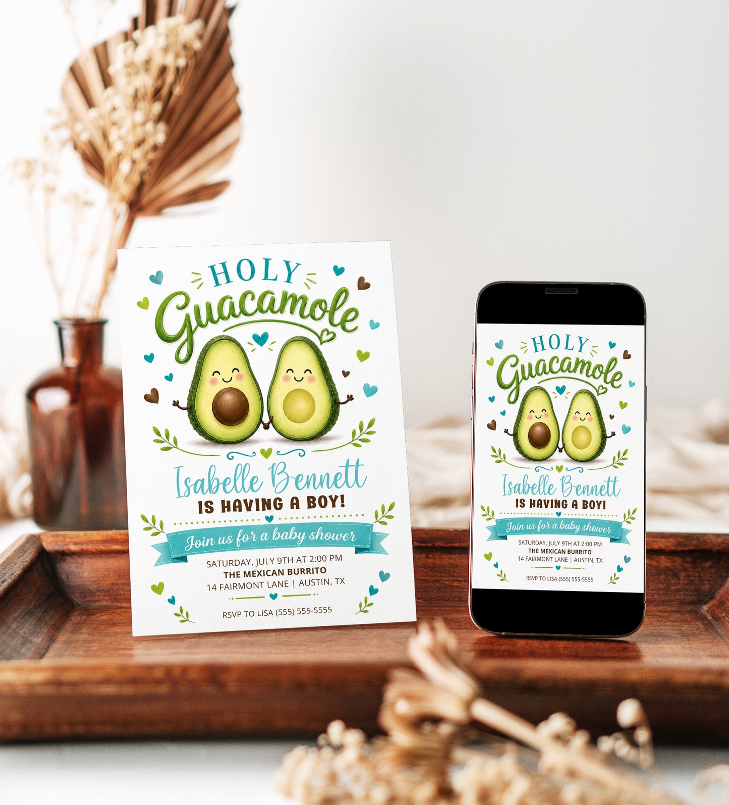 Holy guacamole baby shower invitation with cute smiling avocado characters, teal hearts, greenery accents, playful lettering, and green brown baby boy details