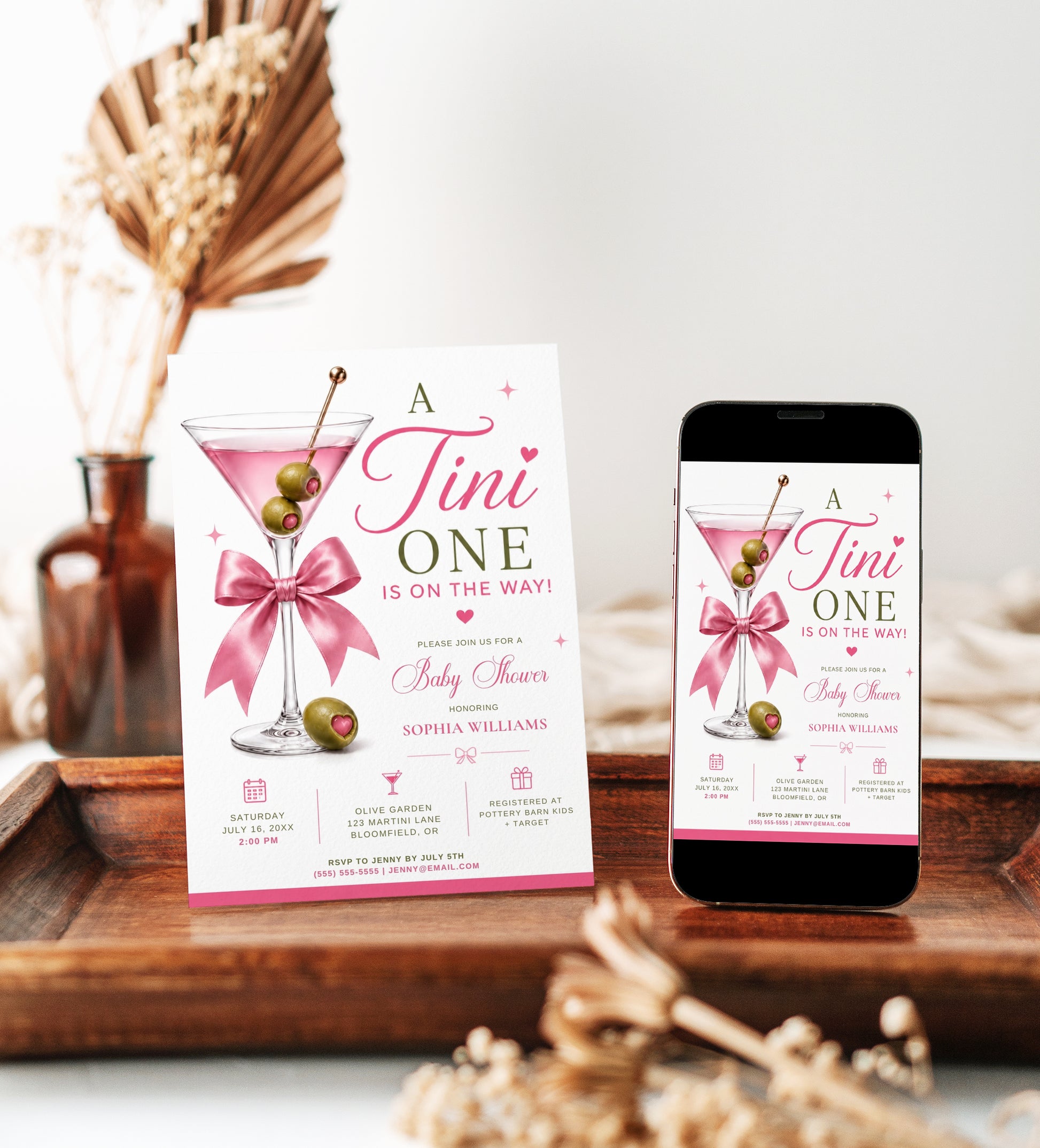 Editable martini baby shower invitation Canva template with pink martini glass, satin bow, heart-topped olive garnish, sparkle accents, and playful pink and olive green typography on a white background