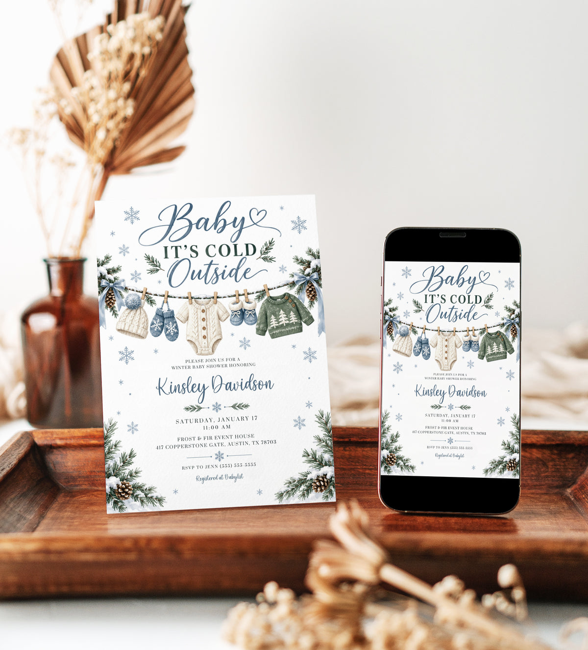 Editable Baby It's Cold Outside baby shower invitation template with snowflakes, pine branches, and blue bows