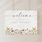 Horizontal wildflower baby shower welcome sign template with watercolor meadow flowers in yellow, purple, and cream, editable in Canva