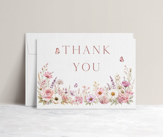 Editable wildflower folded thank you card Canva template with watercolour roses, lavender, daisies, and butterfly details on a white background, shown as a folded card mockup