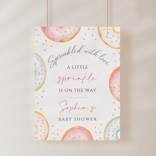 Editable donuts and sprinkles baby shower welcome sign Canva template with watercolour pastel donuts, rainbow sprinkles, and script typography on a soft white background