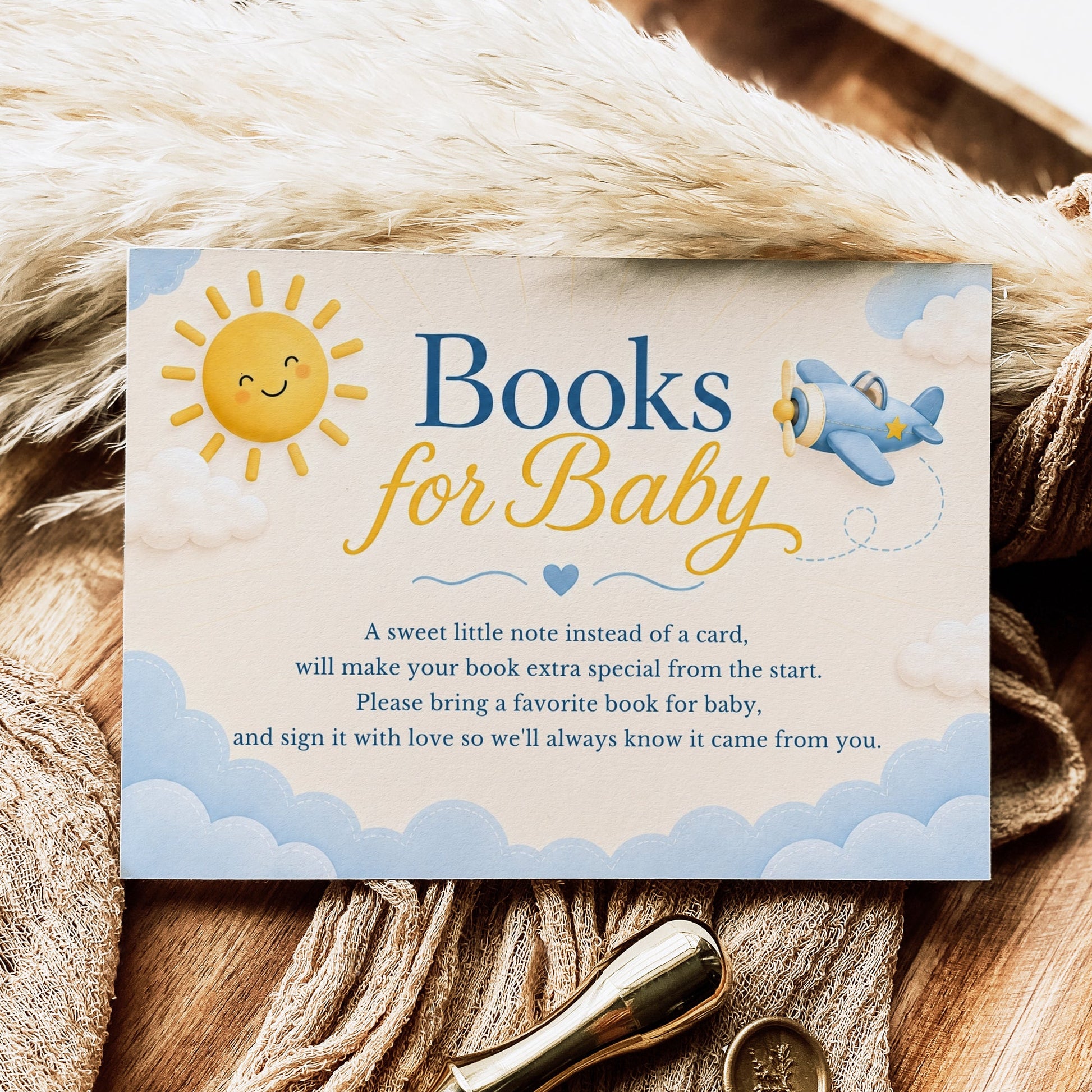 Editable here comes the son books for baby card Canva template with smiling sun, blue toy airplane, fluffy clouds, and navy and golden script typography on a warm cream background, landscape orientation