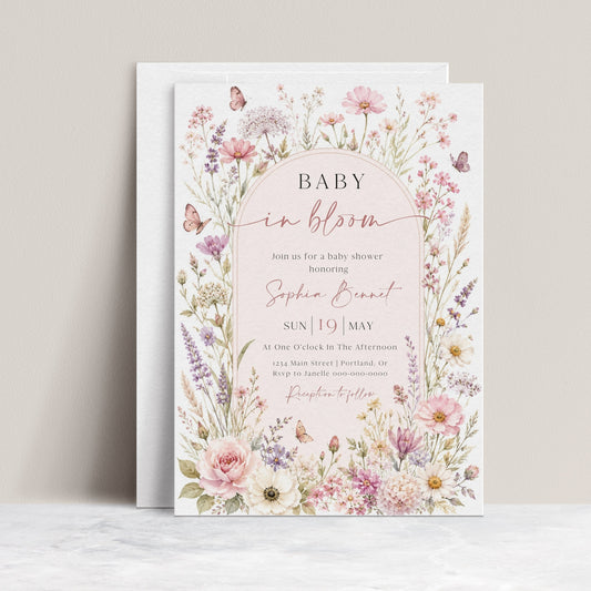 Editable baby in bloom wildflower baby shower invitation Canva template with watercolour roses, cosmos, lavender, and butterfly details framing a blush arch, shown with front and back of card
