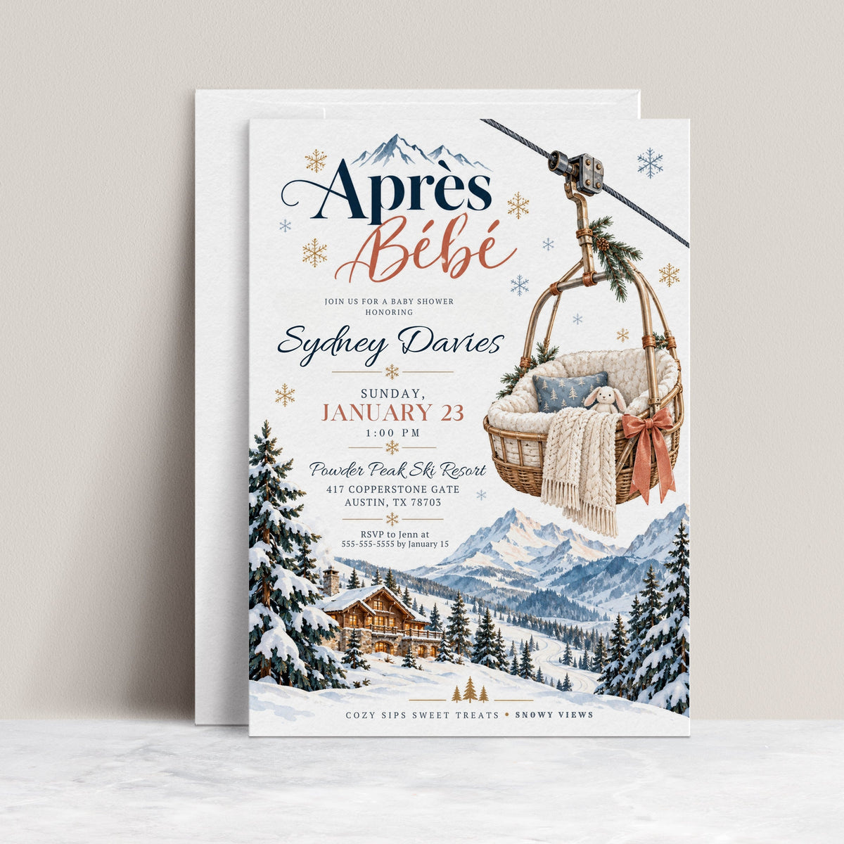 Après Bébé baby shower invitation with a basket-style ski lift holding a plush bunny and knit blanket above snowy mountains, evergreen trees, and a ski chalet