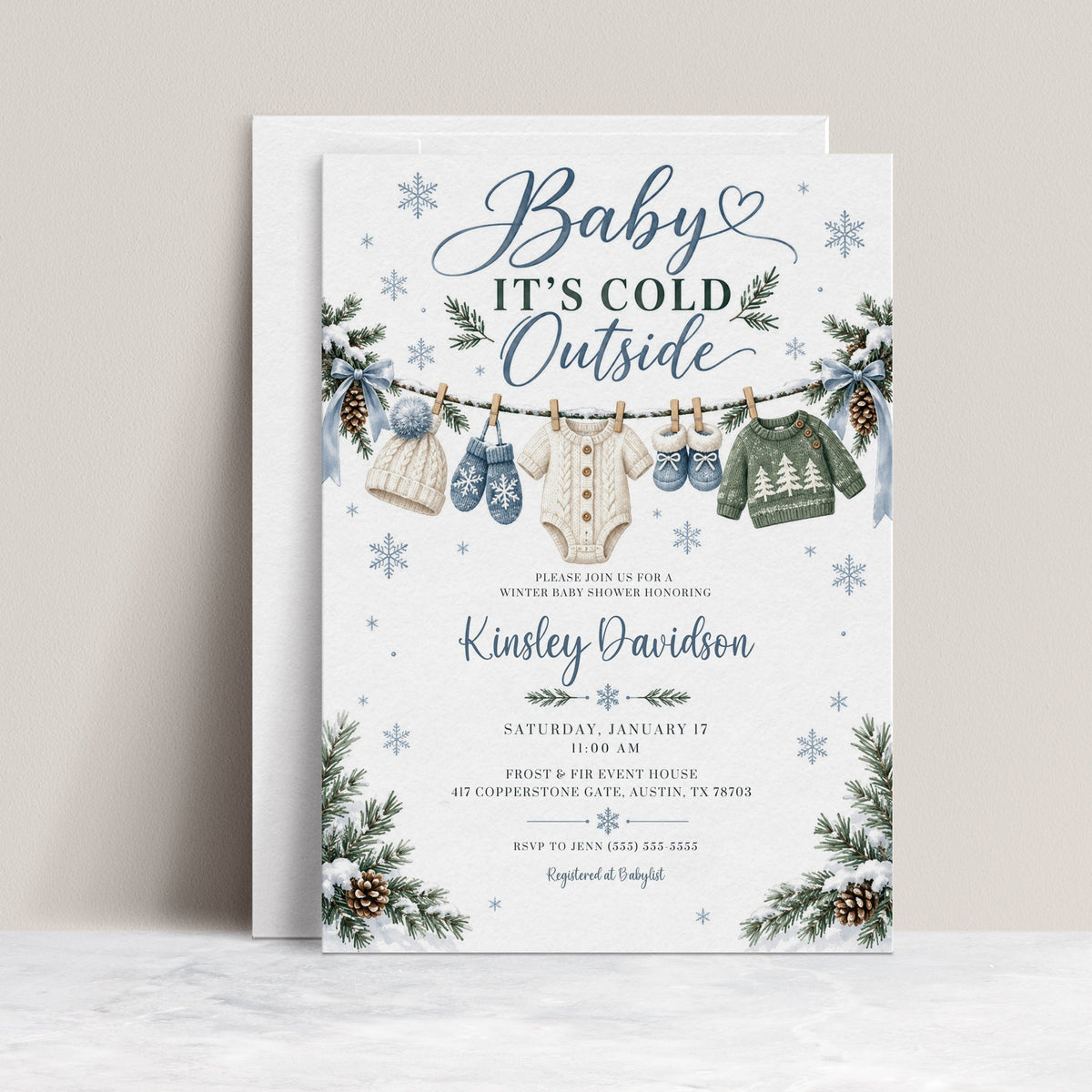 Editable Baby It's Cold Outside baby shower invitation template with snowflakes, pine branches, and blue bows