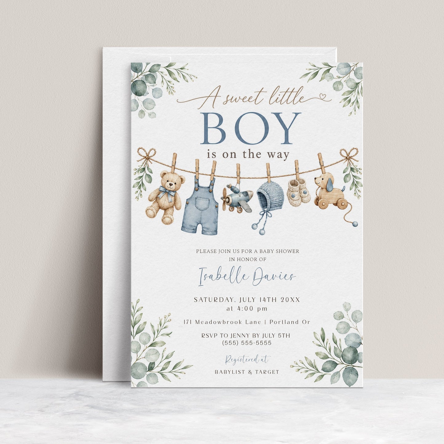 Editable boy baby shower invitation Canva template with watercolour clothesline scene featuring denim overalls, knit bonnet, booties, toy airplane, wooden pull dog, and teddy bear with eucalyptus border on a white background