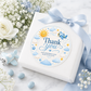 Editable here comes the son baby shower round thank you sticker Canva template with smiling sun, blue toy airplane, fluffy clouds, and gold and blue star accents on a cream background