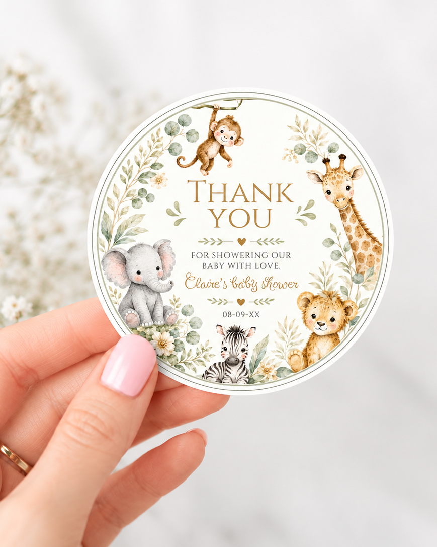 Editable safari baby shower round thank you sticker Canva template with watercolour monkey, giraffe, elephant, lion cub, and zebra in a eucalyptus and tropical leaf wreath on a cream background