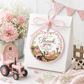 Round barnyard birthday thank-you sticker featuring a pink tractor, barn, cow, pig, pony, chick, puppy, kitten, flowers and pastel bunting.
